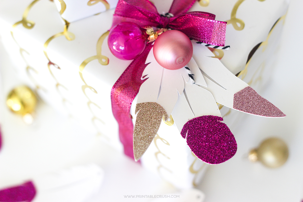 This holiday season, wow everyone with these FREE Feather Gift Tag Cut File and Unique Gift Wrapping Idea! These glitter tipped feathers are GORGEOUS!